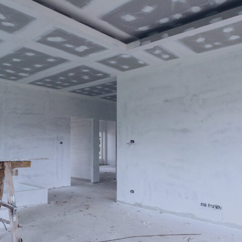Empty room interior with gypsum board ceiling at house construction site